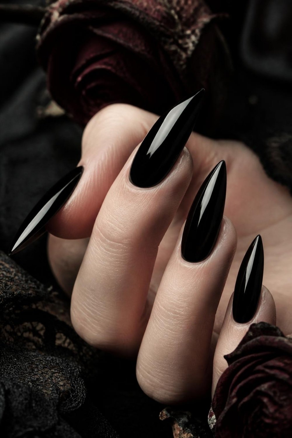 Glossy black stiletto gothic nails with a mirror-like shine